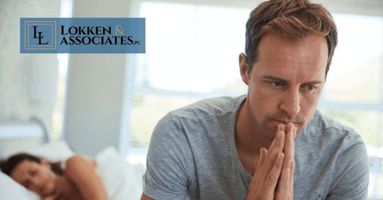 Woman in bed while man seriously thinks